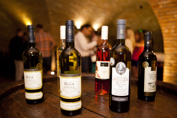 Různé lahve vína se zlatou známkou Sysli na vinici